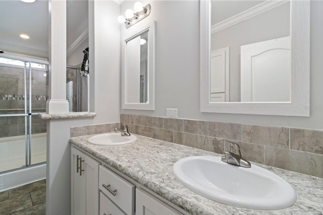 bathroom featuring double vanity, crown molding, an enclosed shower, and a sink