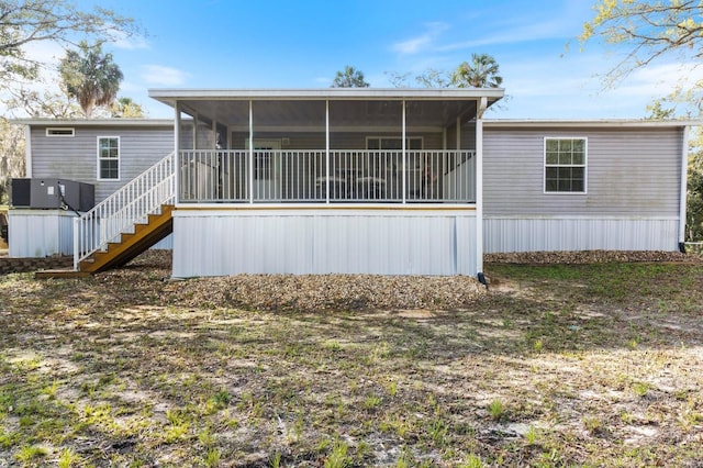 back of house featuring a sunroom, central AC, and stairway