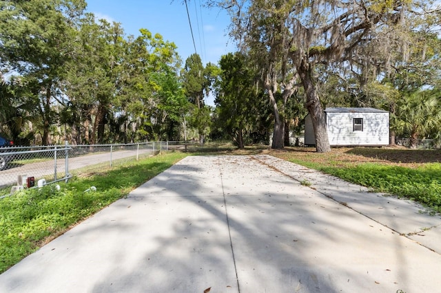 exterior space with an outbuilding, fence, and a storage shed