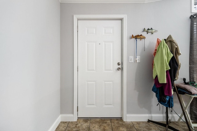 doorway with tile patterned flooring and baseboards