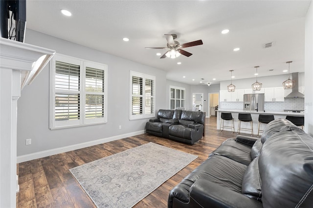 living room featuring baseboards, visible vents, dark wood finished floors, a ceiling fan, and recessed lighting