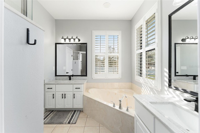 full bath with two vanities, a sink, a bath, and tile patterned floors