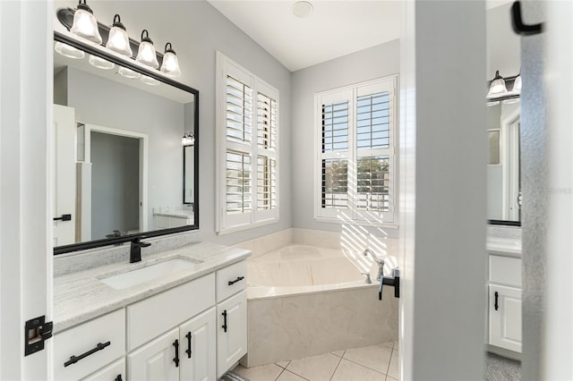 bathroom with tile patterned flooring, a garden tub, and vanity