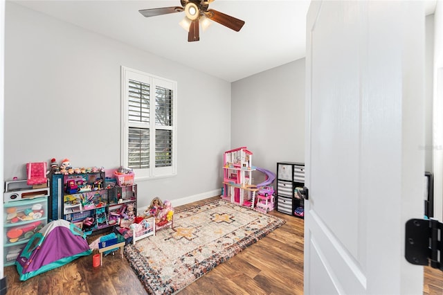 recreation room with ceiling fan, baseboards, and wood finished floors