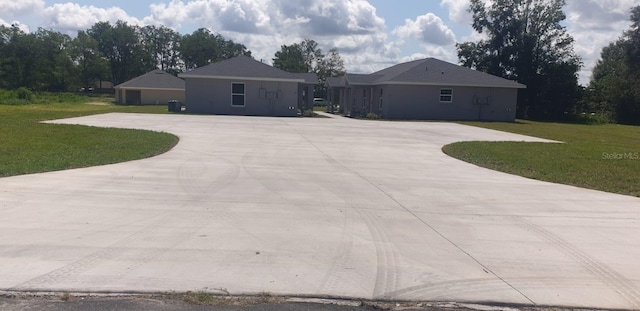 ranch-style home featuring driveway and a front lawn