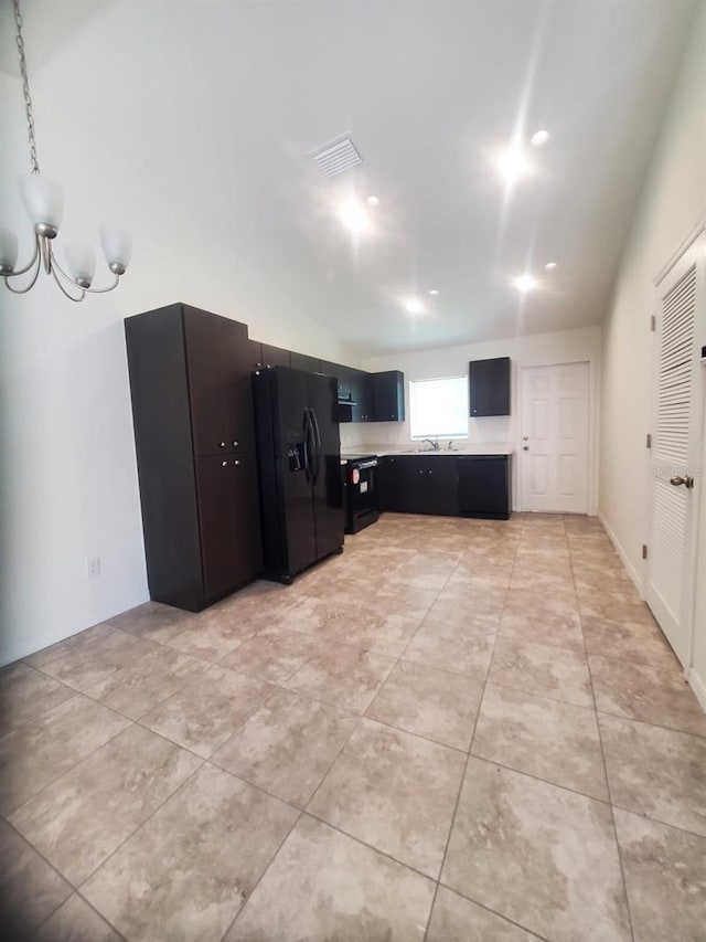 kitchen featuring light tile patterned floors, light countertops, visible vents, dark cabinets, and black appliances