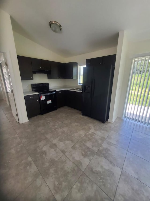 kitchen with light countertops, a sink, dark cabinets, under cabinet range hood, and black appliances