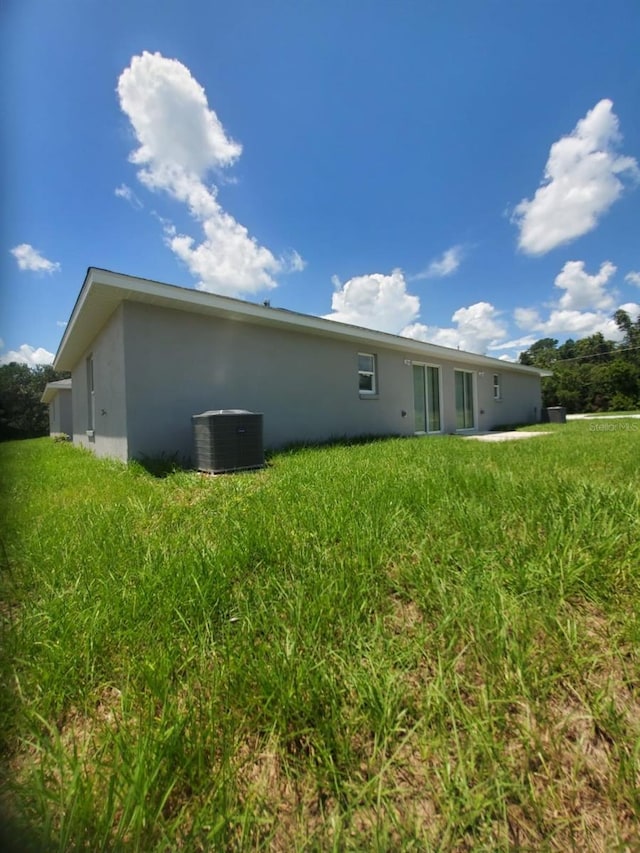 back of property with cooling unit and stucco siding