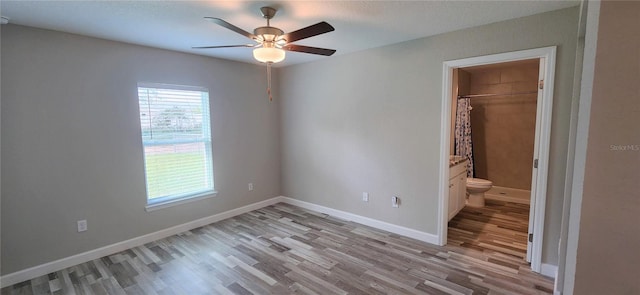 unfurnished bedroom featuring light wood-style flooring, baseboards, and a ceiling fan