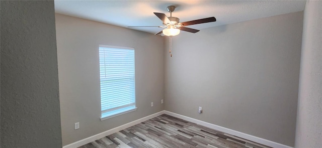 empty room with ceiling fan, light wood-type flooring, and baseboards