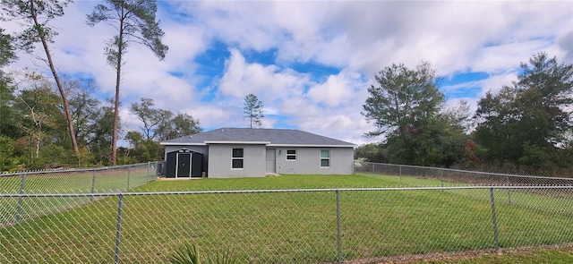 back of house featuring a yard, a fenced backyard, and stucco siding