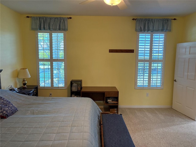 bedroom featuring carpet, multiple windows, baseboards, and ceiling fan