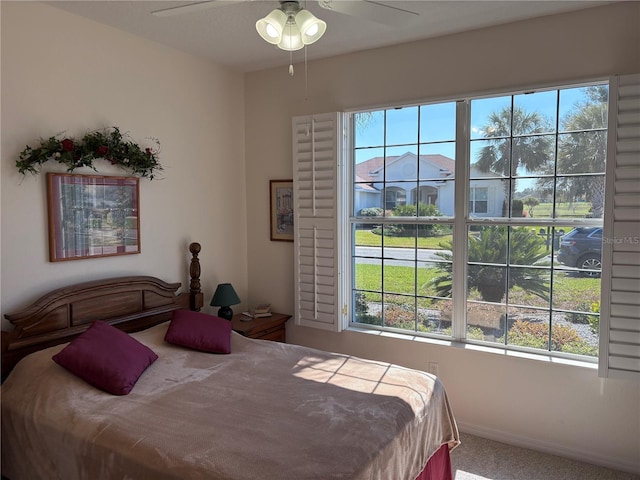 carpeted bedroom with baseboards and a ceiling fan