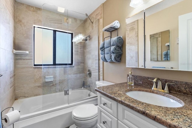 bathroom featuring toilet, enclosed tub / shower combo, and vanity