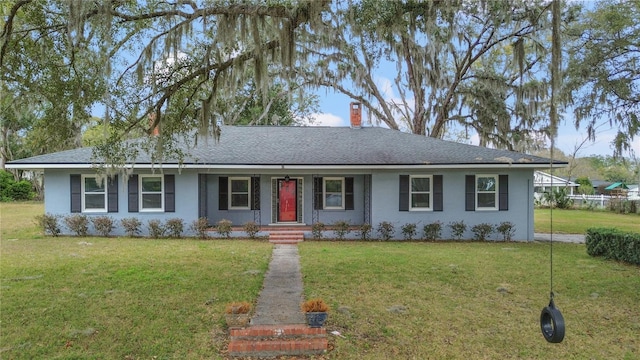 ranch-style home with a front lawn, a chimney, a shingled roof, and stucco siding