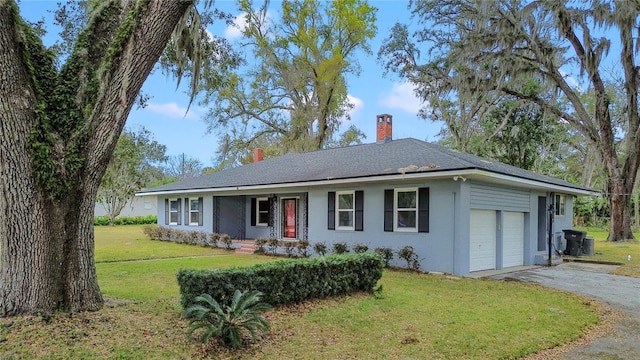 ranch-style house featuring driveway, a chimney, an attached garage, a front lawn, and stucco siding