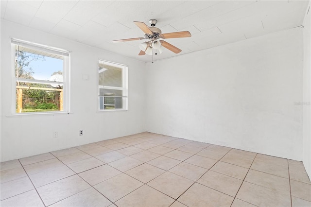 empty room with light tile patterned flooring and a ceiling fan