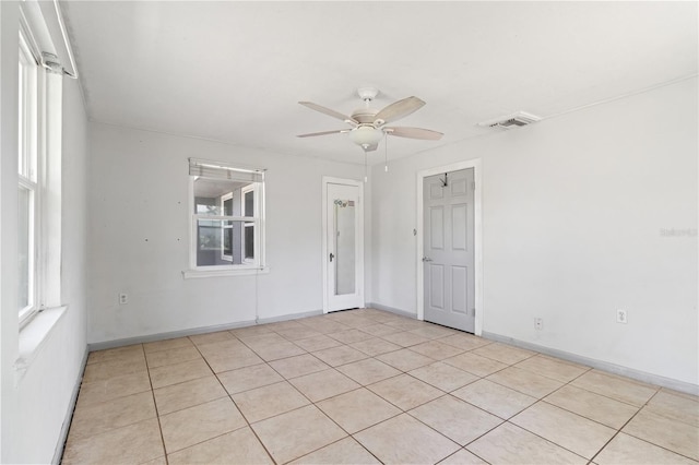 spare room with baseboards, visible vents, and a ceiling fan