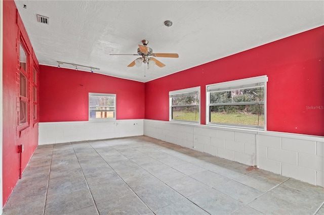 unfurnished room featuring ceiling fan, track lighting, visible vents, and a textured ceiling