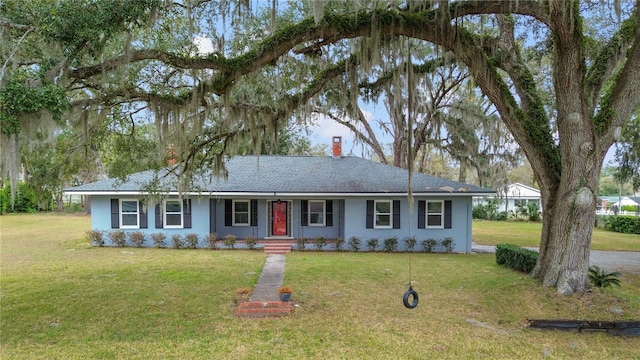 ranch-style house featuring a chimney and a front lawn