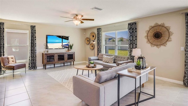 living room with light tile patterned floors, a ceiling fan, visible vents, and baseboards