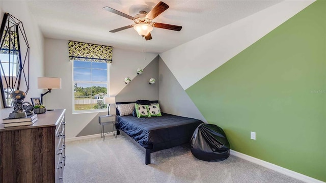 bedroom with a textured ceiling, light colored carpet, a ceiling fan, baseboards, and vaulted ceiling