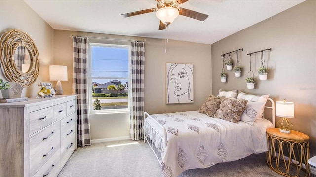 bedroom with ceiling fan, baseboards, and light colored carpet