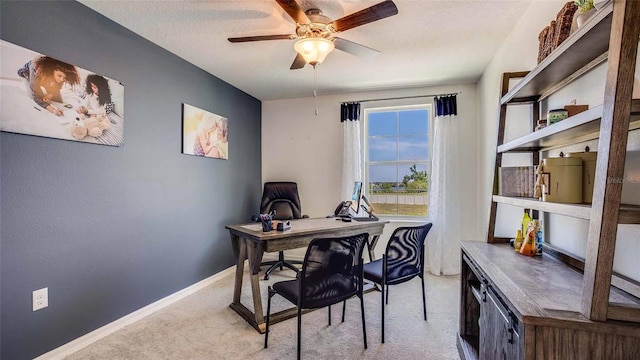 office area featuring light carpet, ceiling fan, baseboards, and a textured ceiling