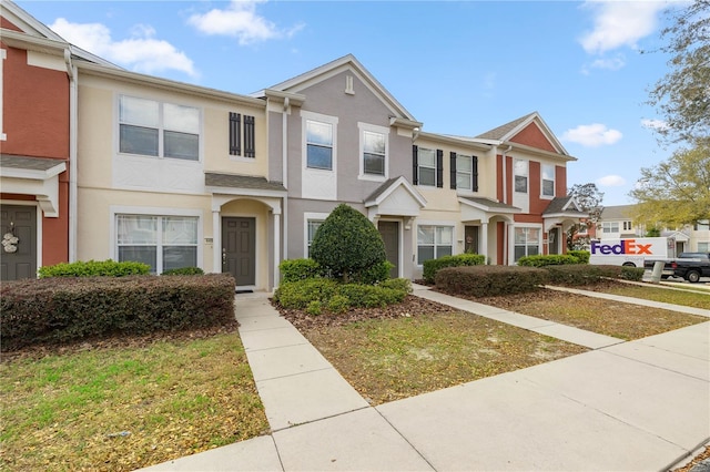 townhome / multi-family property featuring a residential view and stucco siding