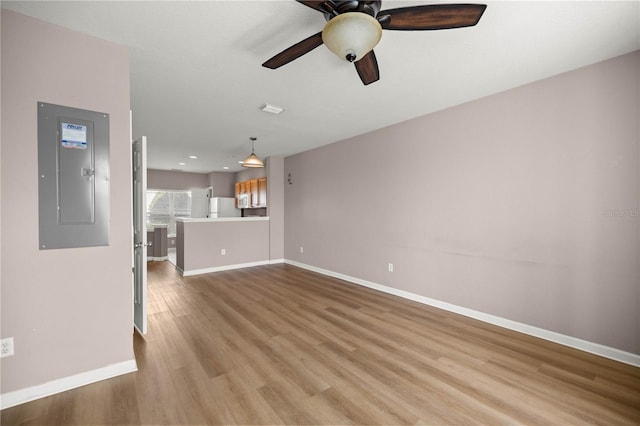 unfurnished living room with ceiling fan, visible vents, baseboards, light wood-type flooring, and electric panel