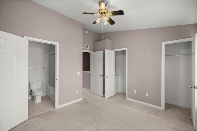 unfurnished bedroom with ensuite bathroom, light colored carpet, visible vents, baseboards, and vaulted ceiling