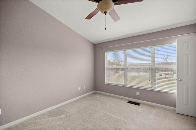 unfurnished room featuring visible vents, baseboards, vaulted ceiling, and light colored carpet