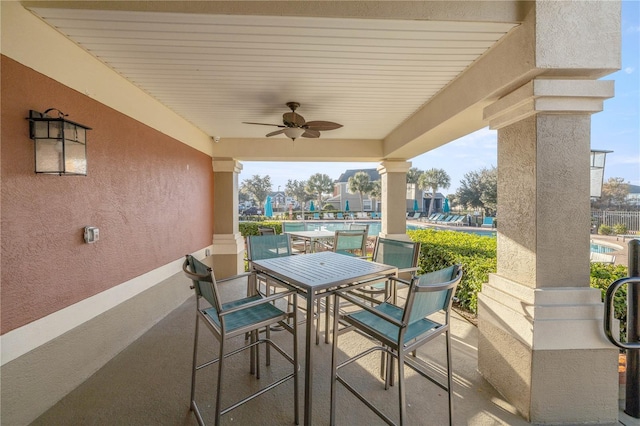 view of patio / terrace with a ceiling fan, outdoor dining area, and a community pool