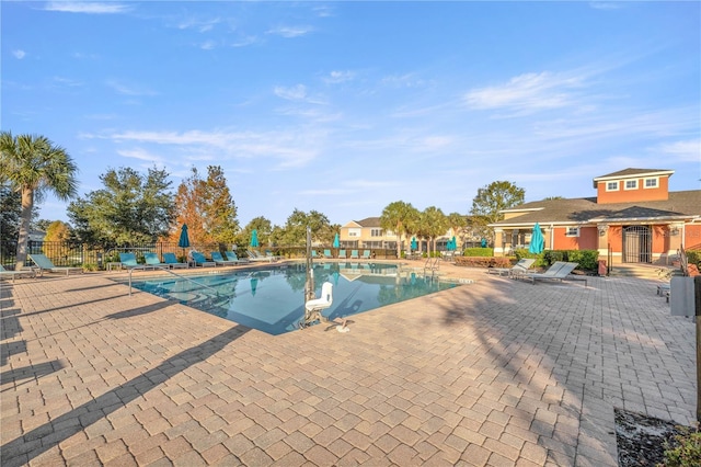 community pool featuring fence and a patio