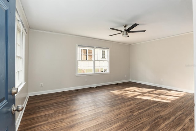 spare room featuring baseboards, visible vents, a ceiling fan, dark wood-style floors, and ornamental molding