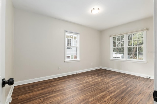 empty room featuring dark wood finished floors and baseboards