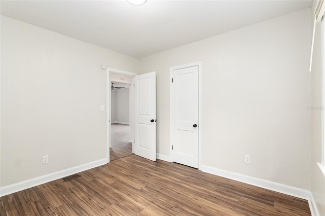 unfurnished bedroom with wood finished floors, visible vents, and baseboards