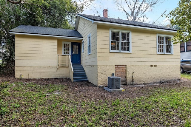 rear view of property featuring crawl space, a chimney, cooling unit, and entry steps