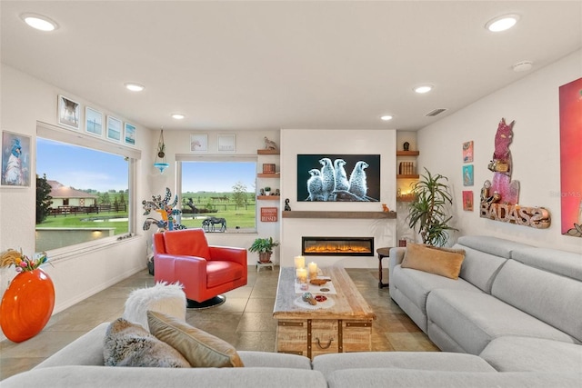 living room featuring tile patterned floors, a glass covered fireplace, visible vents, and recessed lighting