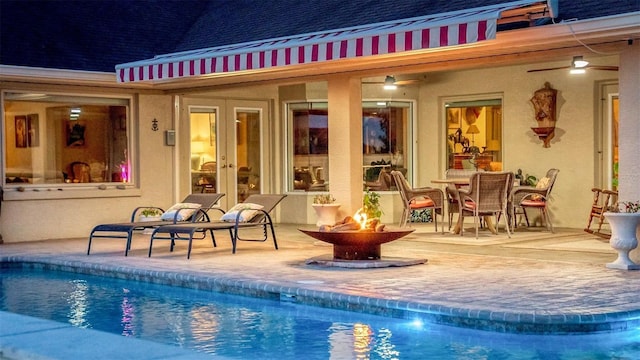 outdoor pool featuring an outdoor fire pit, a patio, and french doors