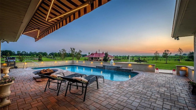 pool at dusk featuring a yard, a patio area, fence, and an outdoor pool