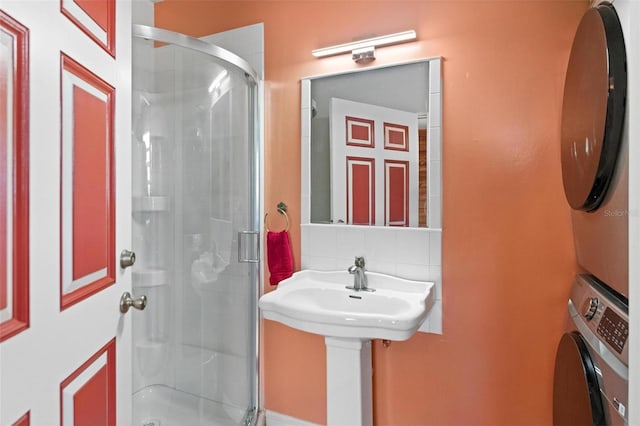 3550 SE 165th Ave, Morriston, FL 32668 - full bathroom featuring stacked washer and clothes dryer, a stall shower, and backsplash