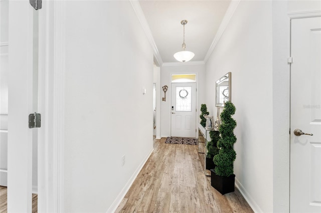 entryway featuring ornamental molding, light wood-type flooring, and baseboards