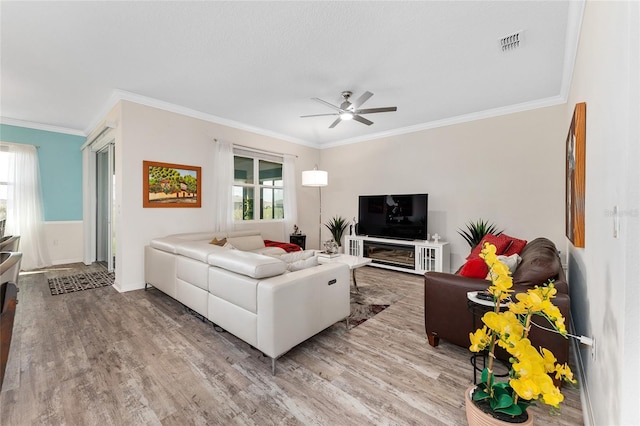 living area featuring plenty of natural light, visible vents, and wood finished floors