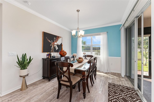 dining room with crown molding, a notable chandelier, light wood-style flooring, and baseboards