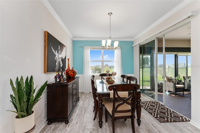 dining space with a chandelier, ornamental molding, light wood-type flooring, and a healthy amount of sunlight