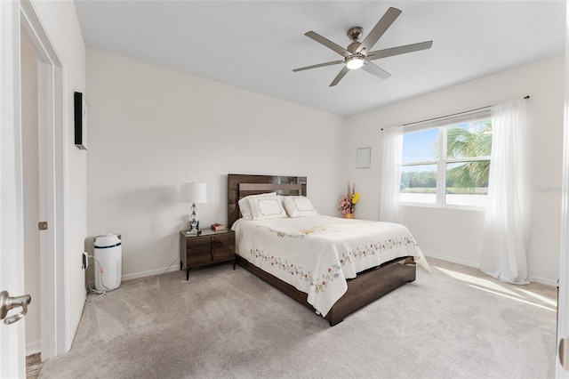 carpeted bedroom with ceiling fan and baseboards