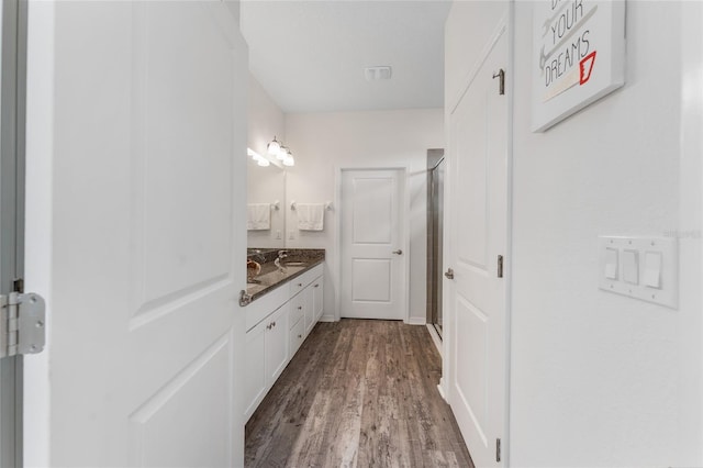 bathroom featuring a stall shower, wood finished floors, and vanity