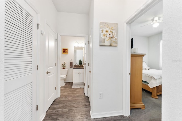 corridor featuring baseboards and wood finished floors