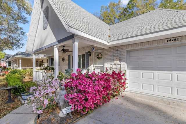 exterior space featuring roof with shingles, an attached garage, covered porch, ceiling fan, and brick siding